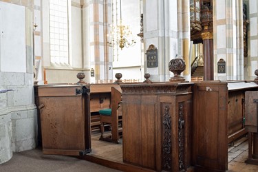 <p><strong>Herengestoelte</strong>: 'De deure zal wijd zijn 2 3/4 voet en na de pilaar opgaan, in twee ijseren hengsels hangen, en door een koperen knoop met een knipjen op en toe gedaan worden. Voor de deure zal een trappe gelegt worden (...) reikende van de pilaar, tot het buitenste eijnde van de pilaster'. In de huidige situatie is het deurtje verplaatst. </p>

